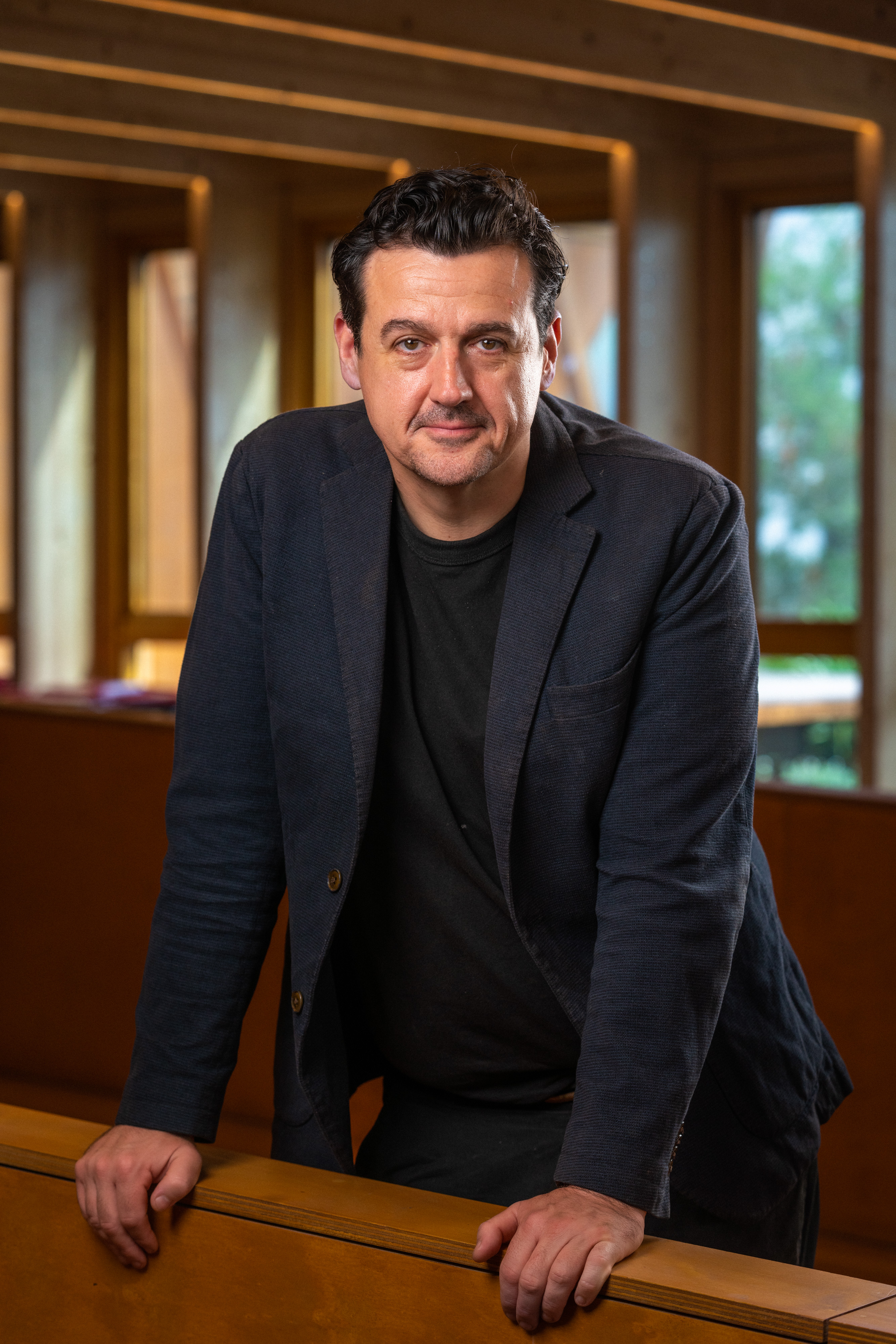 Sam Moran in a dark blazer in an academic setting