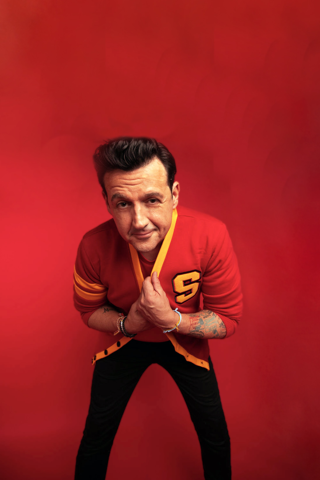 Sam Moran in a playful portrait against red