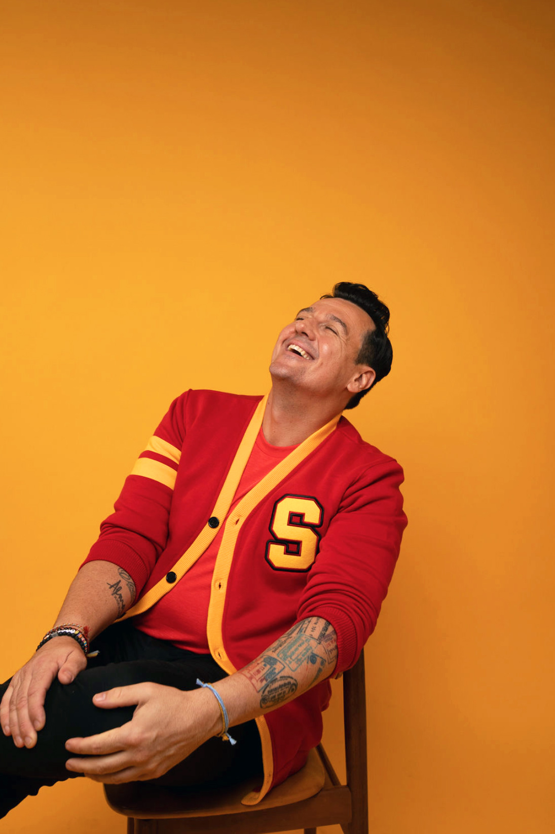 Sam Moran laughing against a yellow background